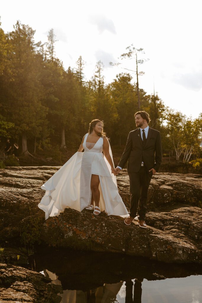 couple posing on rocks on the beach at their Michigan elopement