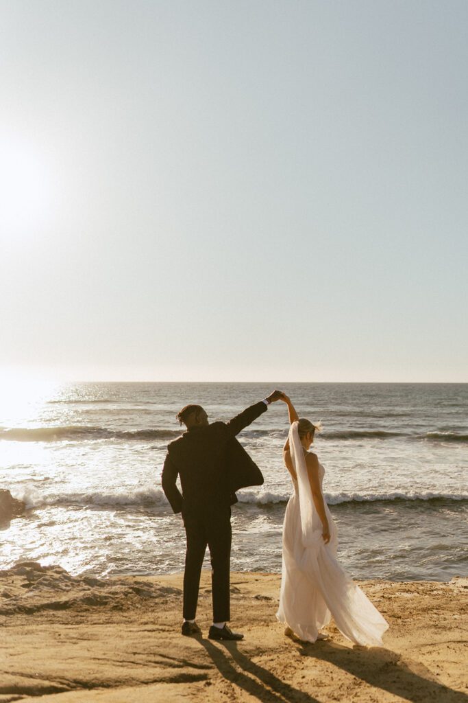 groom spinning bride at this sunset cliffs elopement